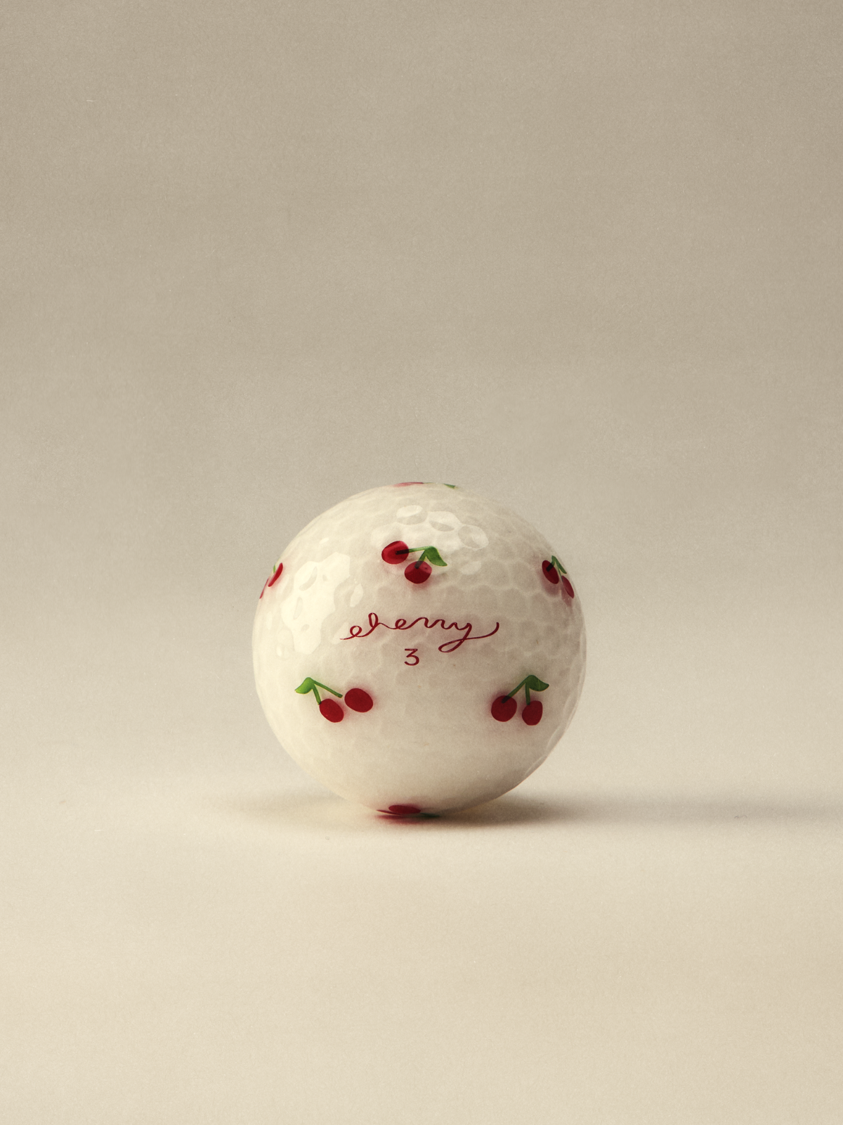 White golf ball with cherry print detail, Cherry Golf Club