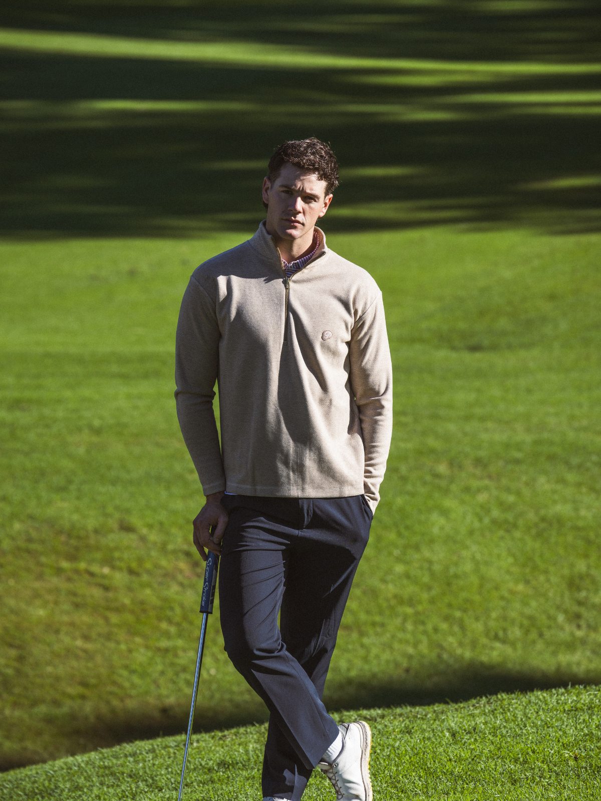 Man wearing Public Drip Herringbone Half Zip in tan, full length shot on golf course fairway
