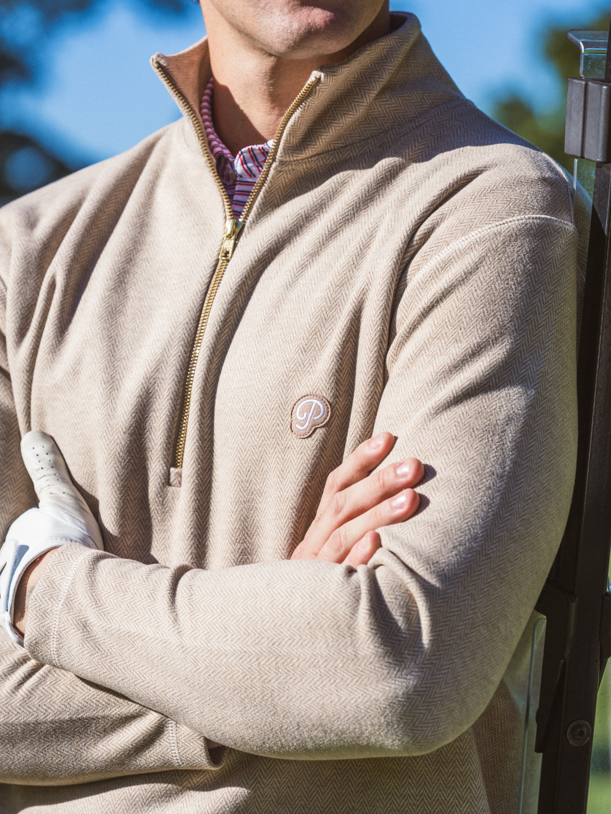 Close-up detail of Public Drip Herringbone Half Zip showing herringbone texture and embroidered logo badge