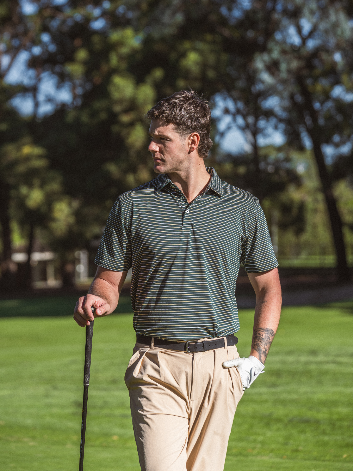 Man wearing Quiet Golf Pine Polo on golf course fairway, front view