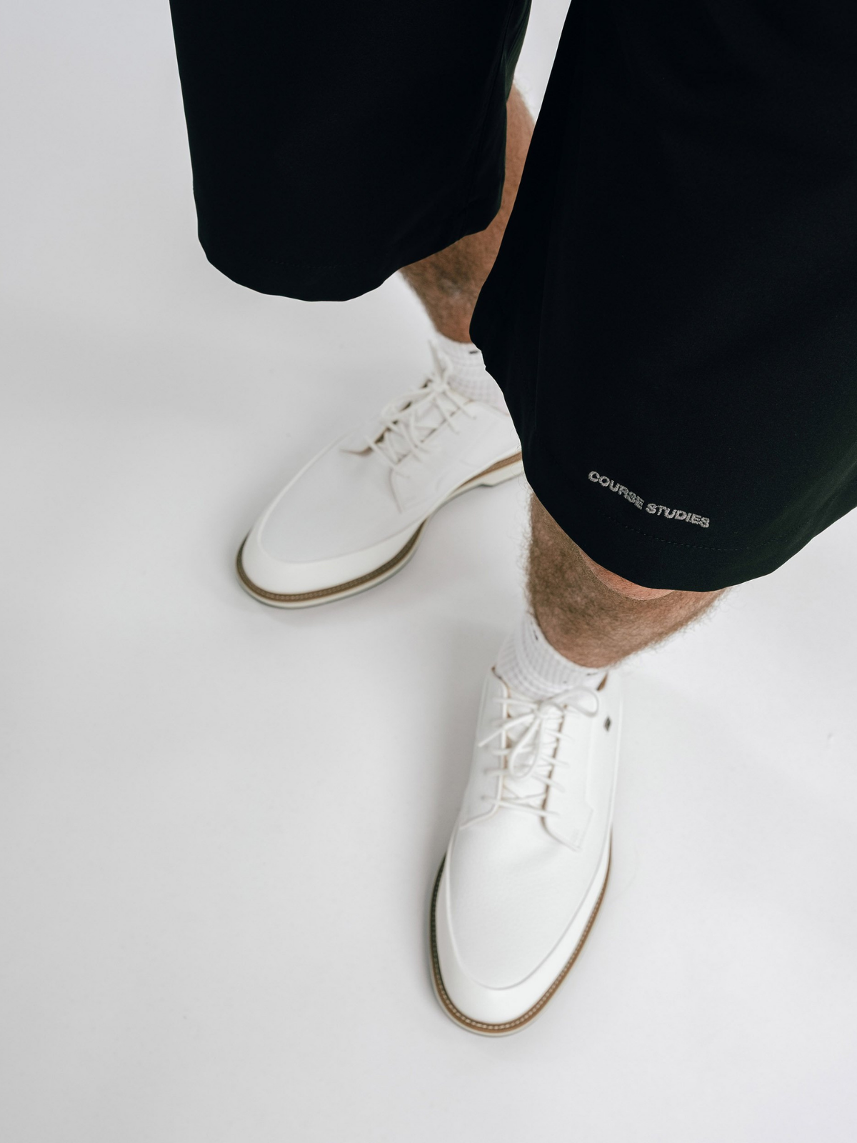 Black Alpina Performance Shorts with embroidered logo, Students Golf, hem detail