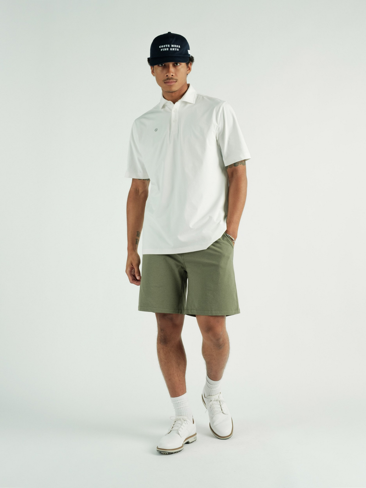 Model wearing white Chaperone Polo, Students Golf, three-quarter view