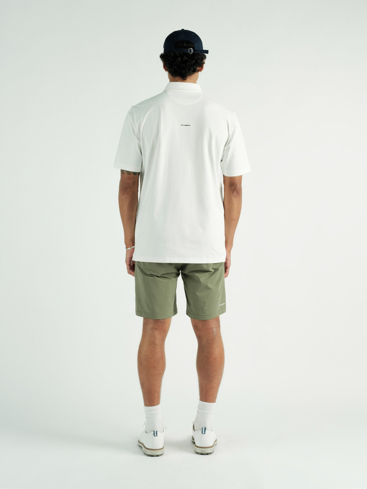 Model wearing white Chaperone Polo, Students Golf, back view