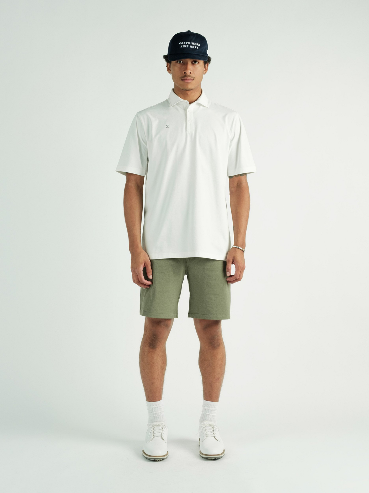 Model wearing white Chaperone Polo, Students Golf, front view