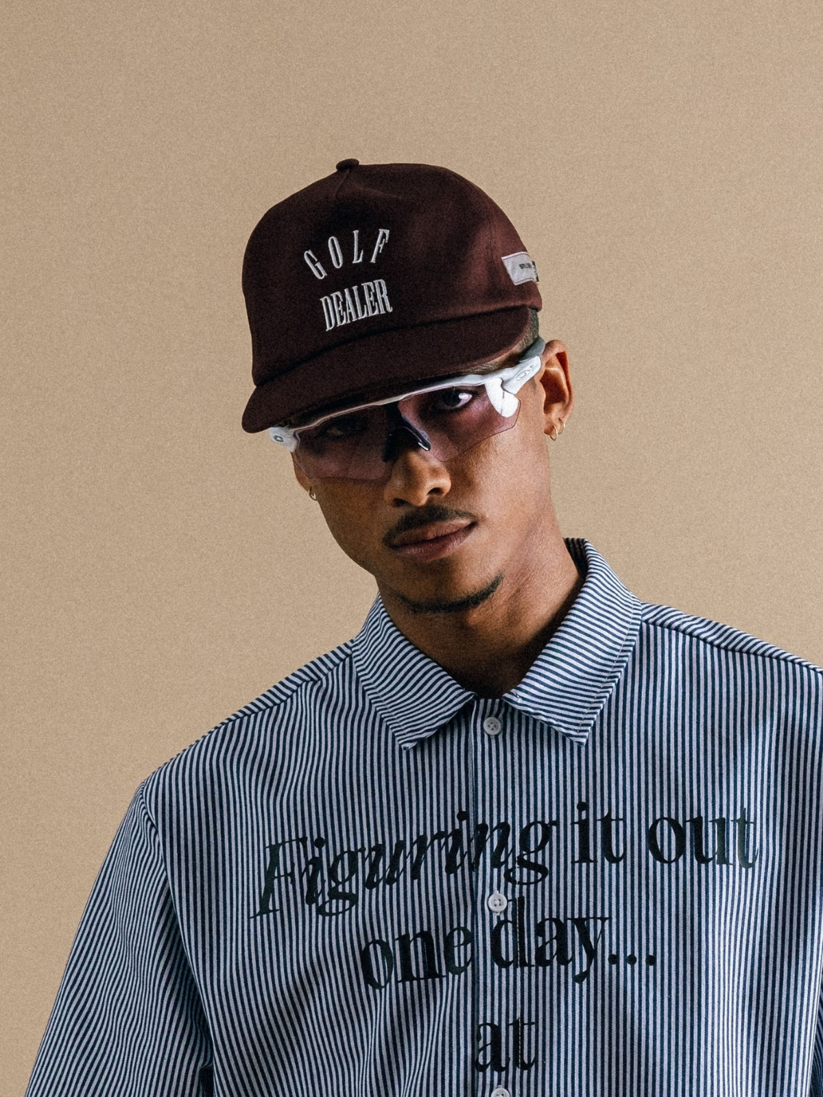 Model wearing brown Golf Dealer cap with blue polo, Students Golf, lifestyle view