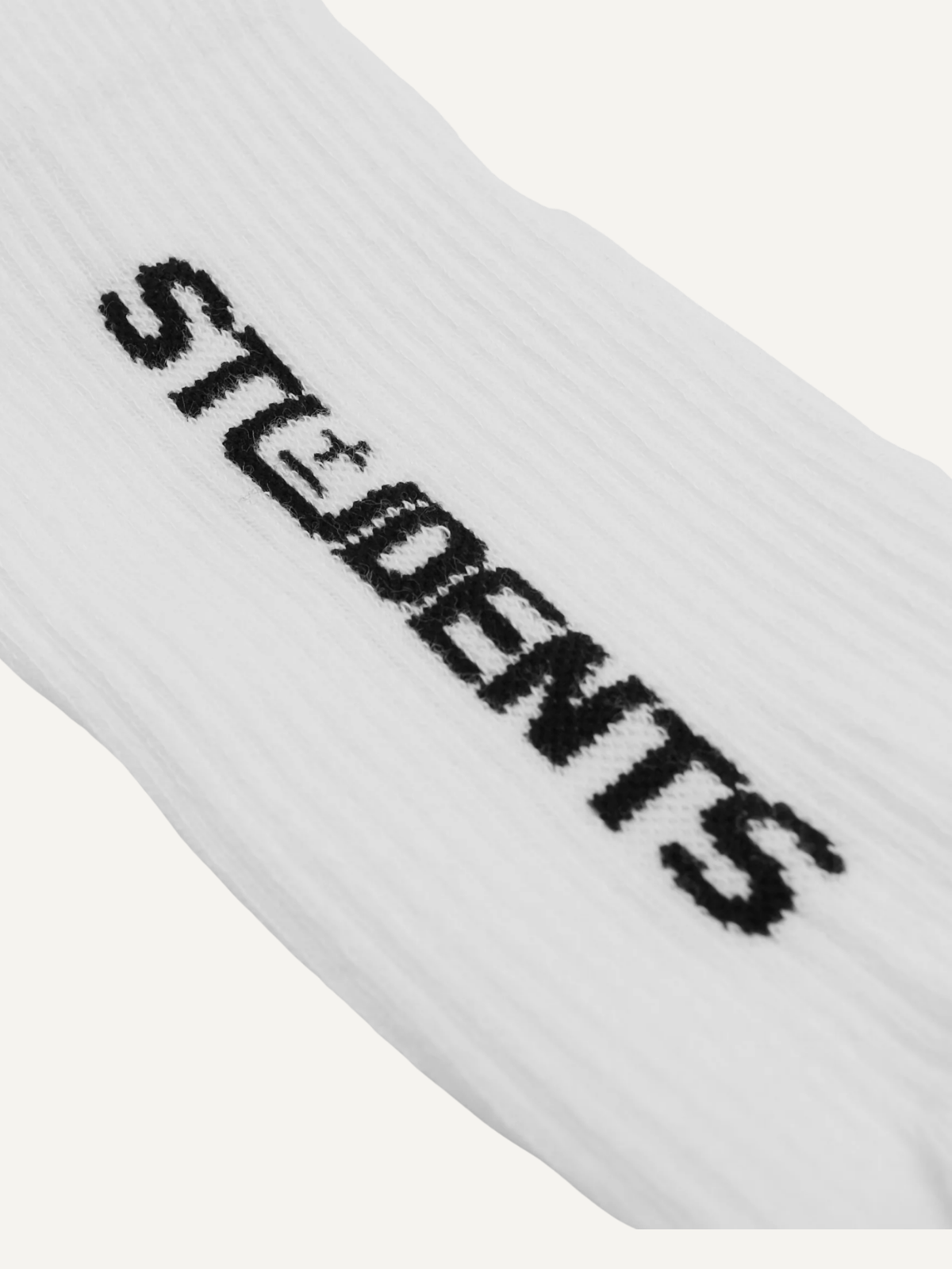 White crew sock with black Students Golf logo, close-up detail